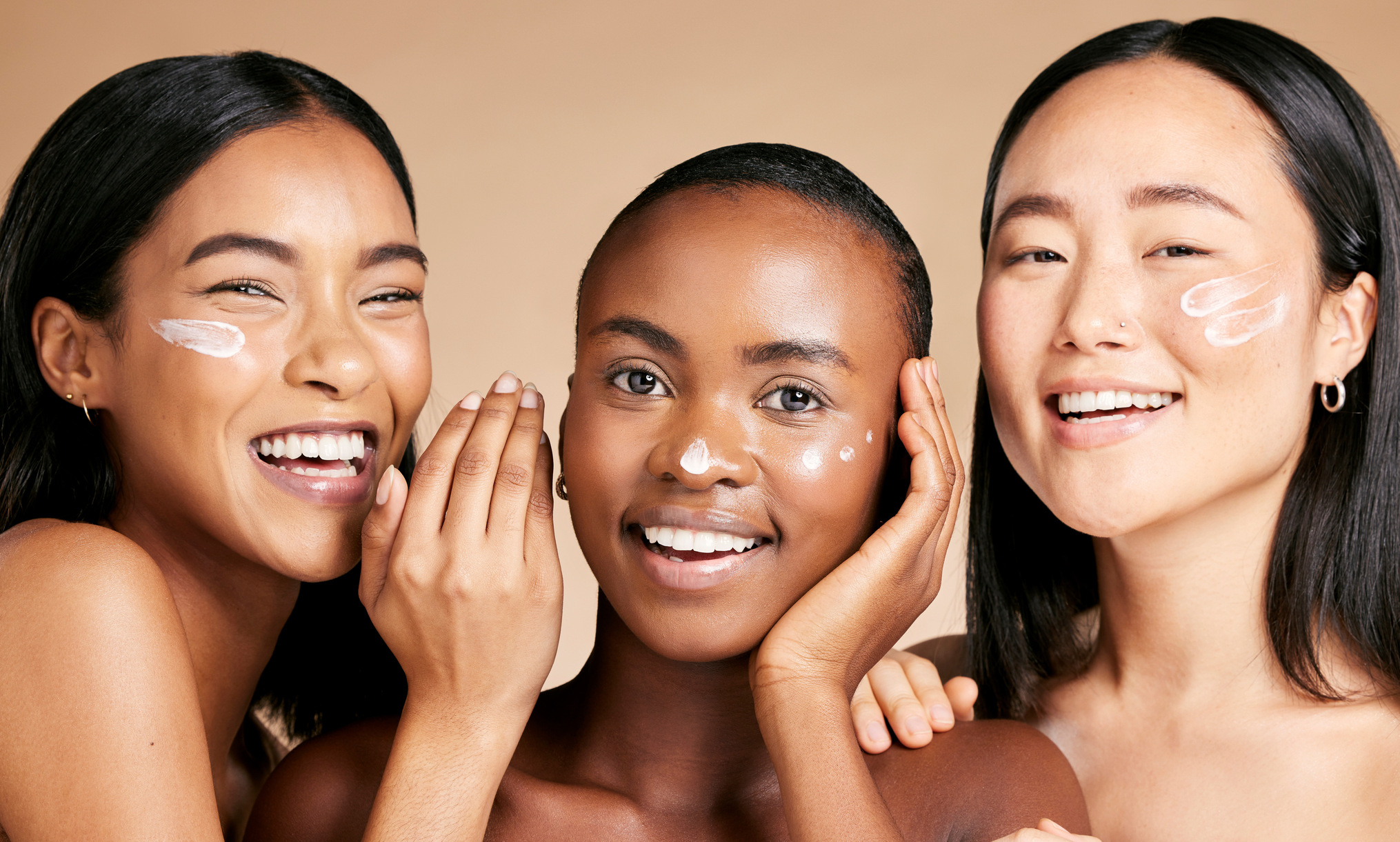 Three women smiling, representing Adelia Skincare's natural beauty brand